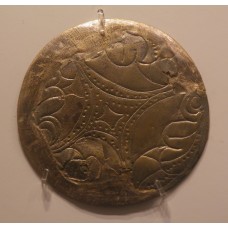 Diamond-like cross engraved on a circular metal sheet